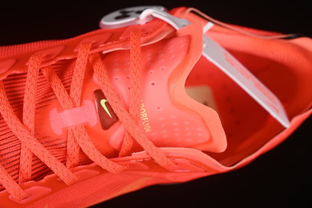 Close-up of the lace area, tongue and interior of the coral-red shoe.