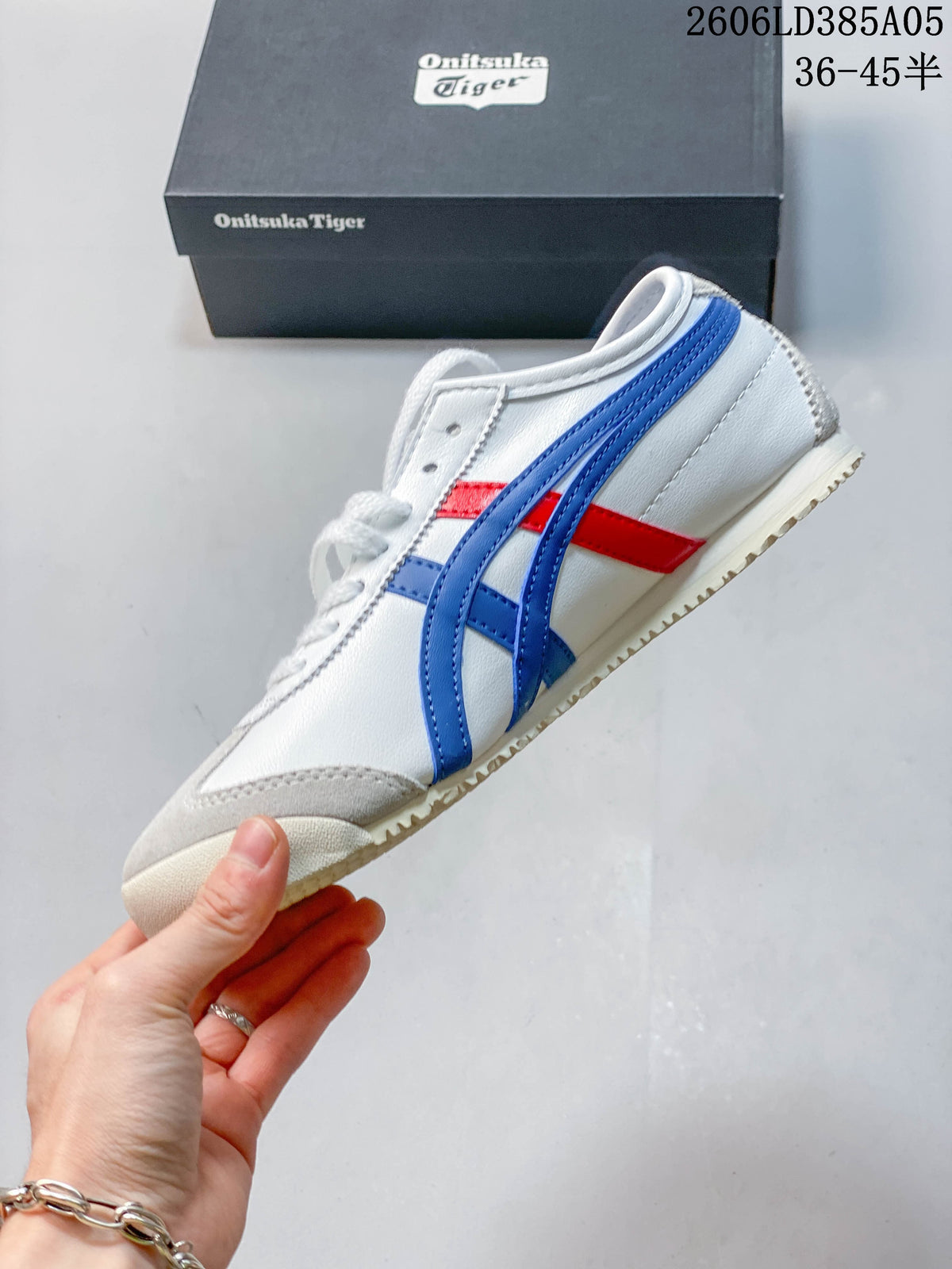 Side profile of the white sneaker with blue stripes, red accents and grey overlays.