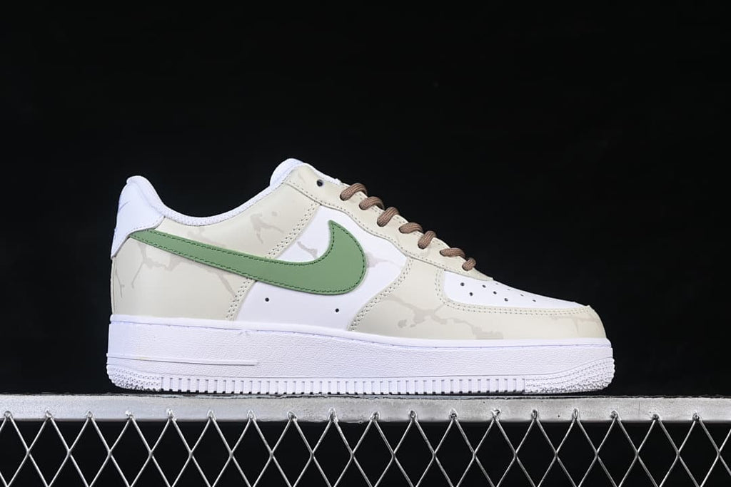 Side profile of the low-top sneaker with cream patterned panels and a green side accent