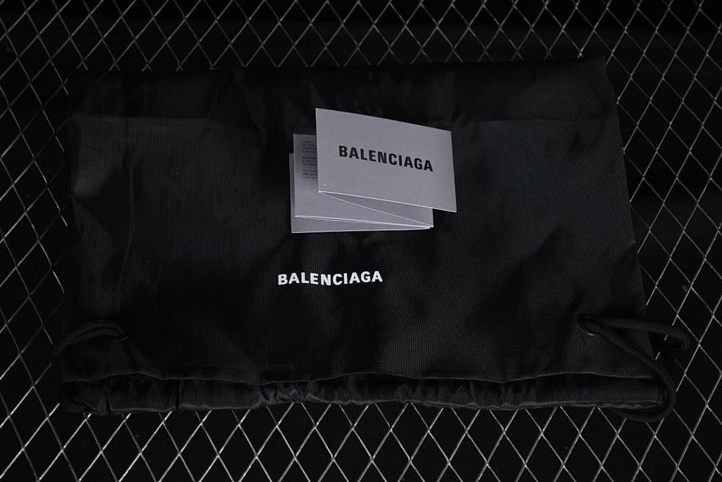 Black branded drawstring bag and cards shown with the sneaker