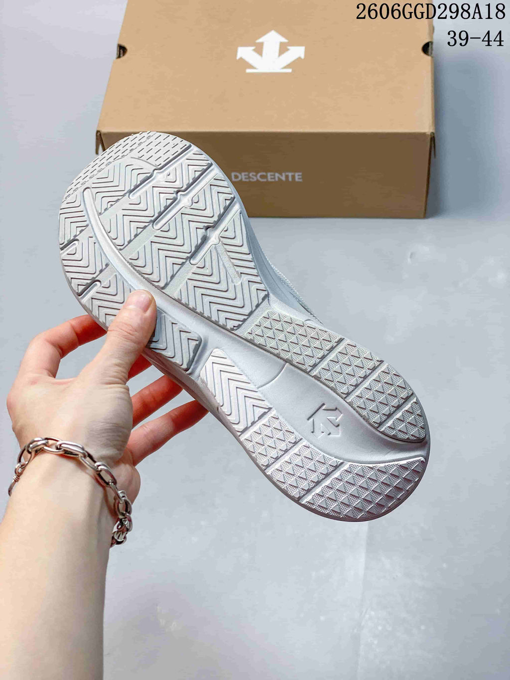 Close-up of the light gray sneaker outsole showing its patterned tread.