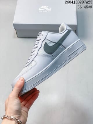 Side view of a light Nike Air Force 1 '07 LV8 sneaker with a dark green Swoosh and textured rubber outsole.