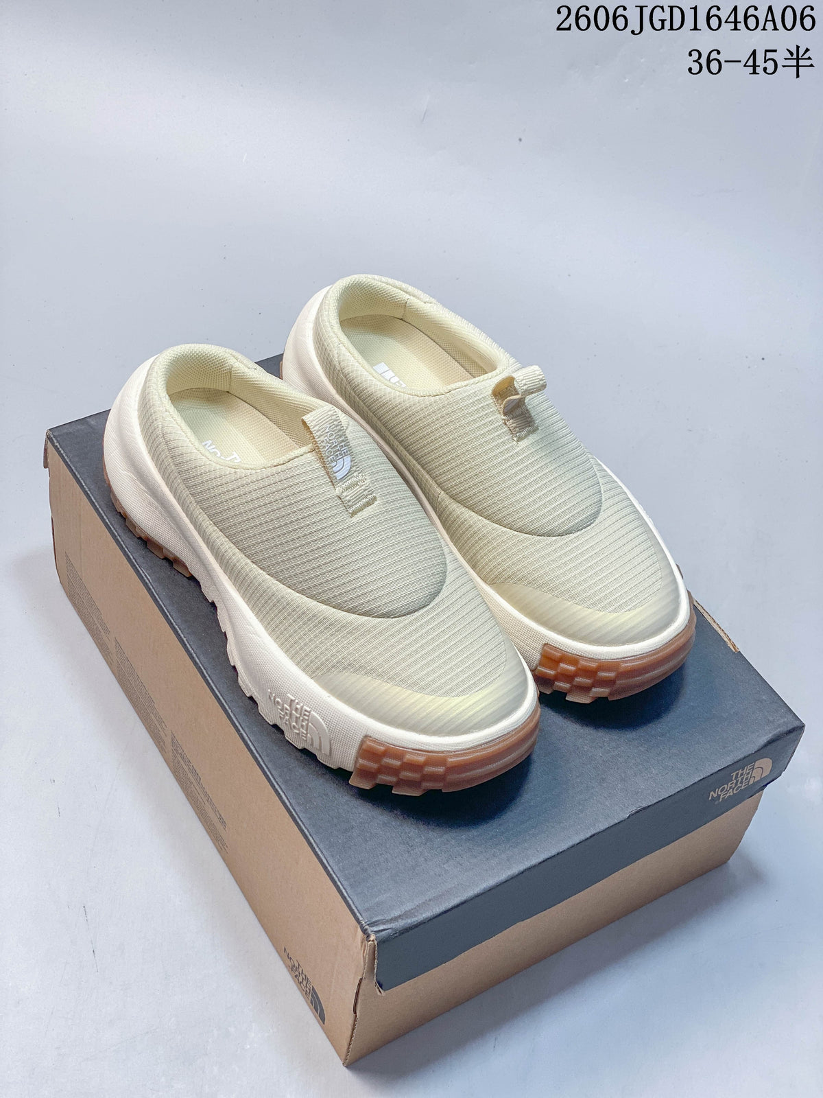 Pair of cream The North Face slip-on mules displayed on a shoebox