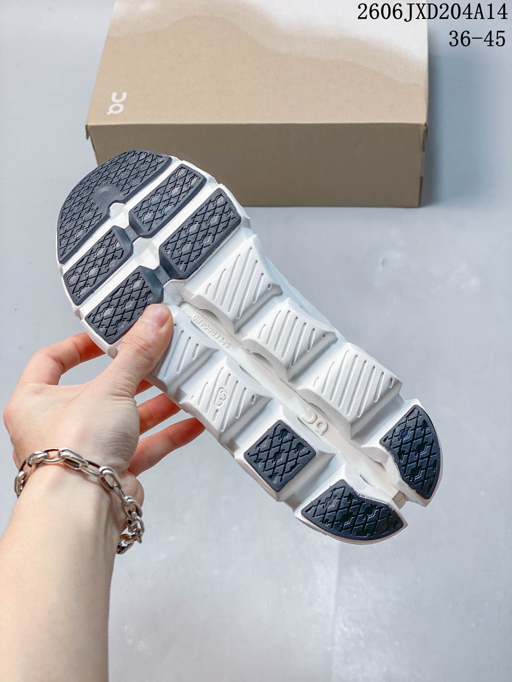 Underside of a white running shoe showing segmented outsole and dark tread sections