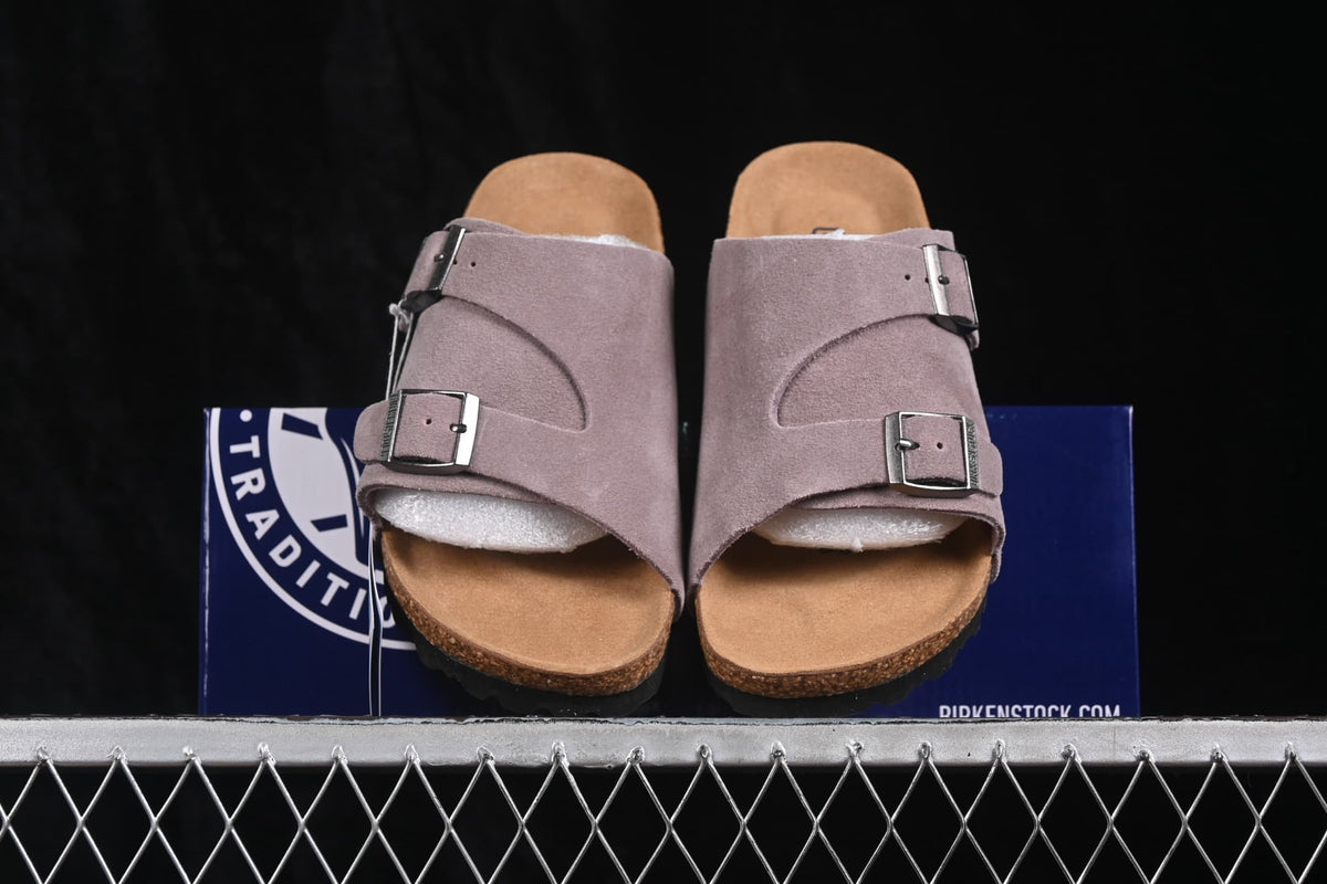 Front view of the lavender two-strap sandals displayed over a product box.