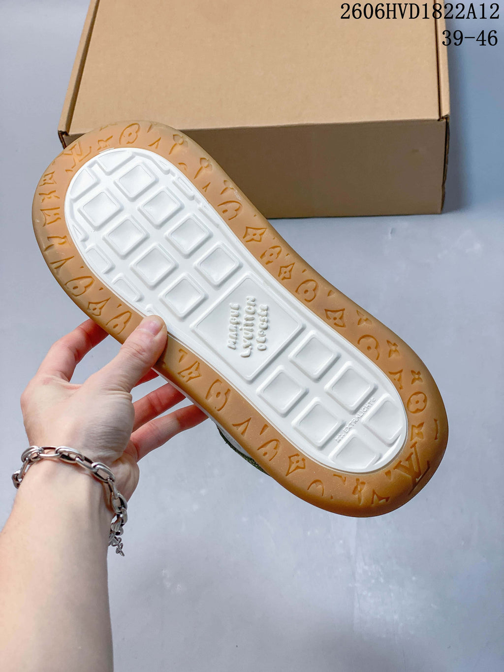Underside of the sneaker showing a white tread center and gum-colored patterned edge