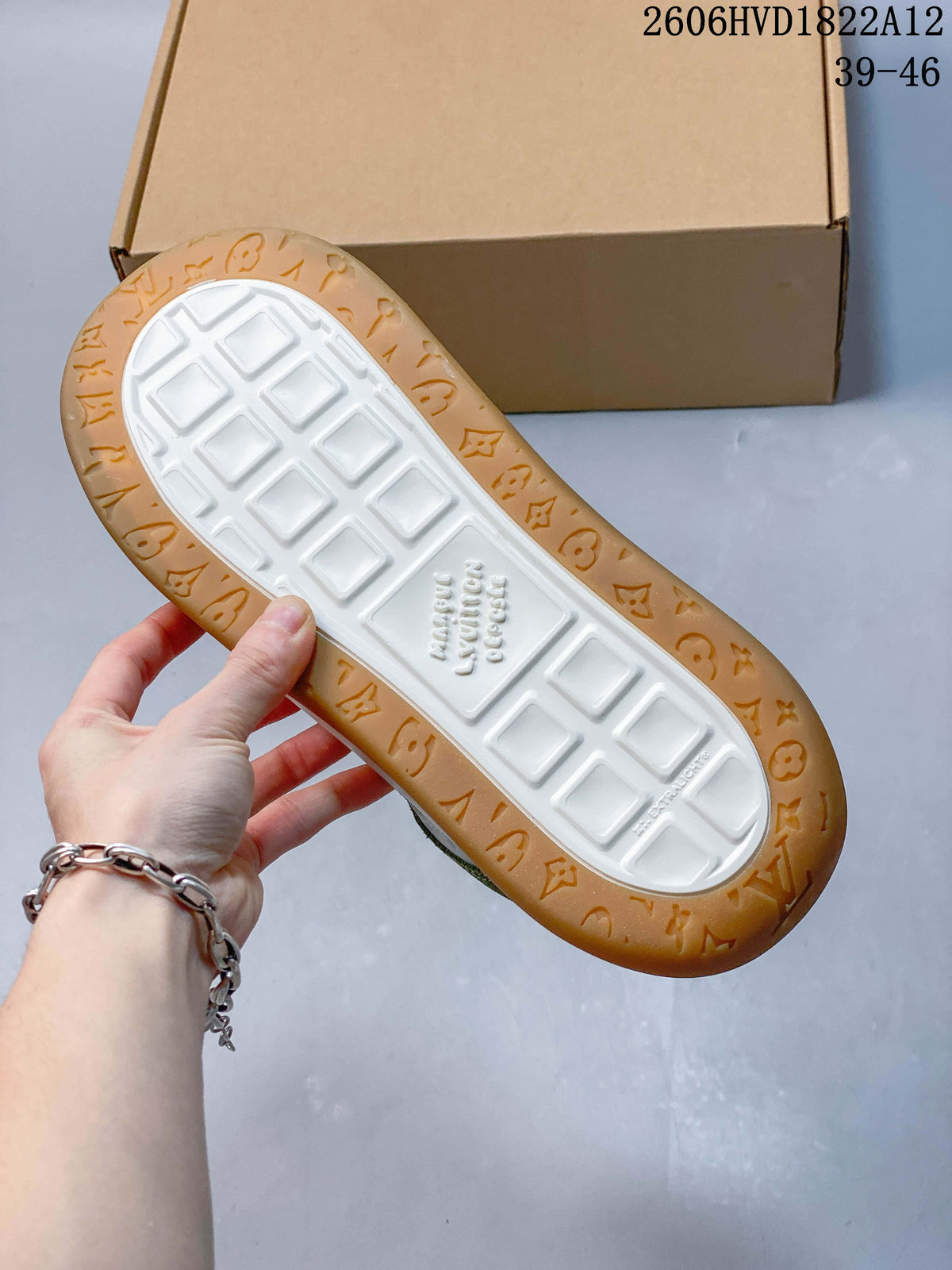 Underside of the sneaker showing a white tread center and gum-colored patterned edge