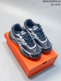 Pair of charcoal and silver Nike Initiator sneakers on an orange box