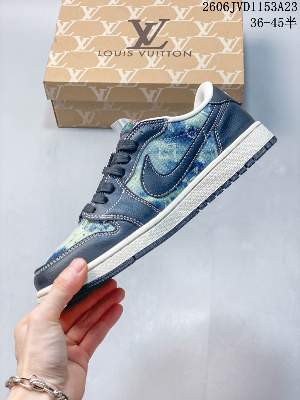 Side view of a low-top sneaker with blue patterned panels, dark overlays, and a white Swoosh