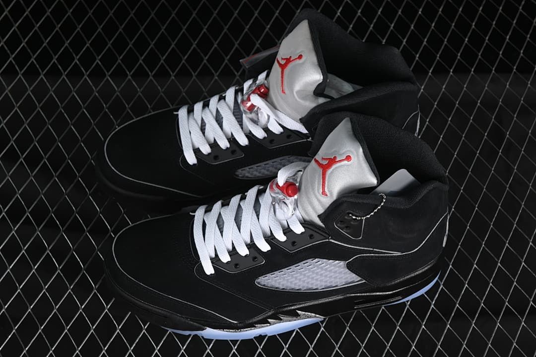 Pair of black Air Jordan 5 sneakers with silver panels and white laces