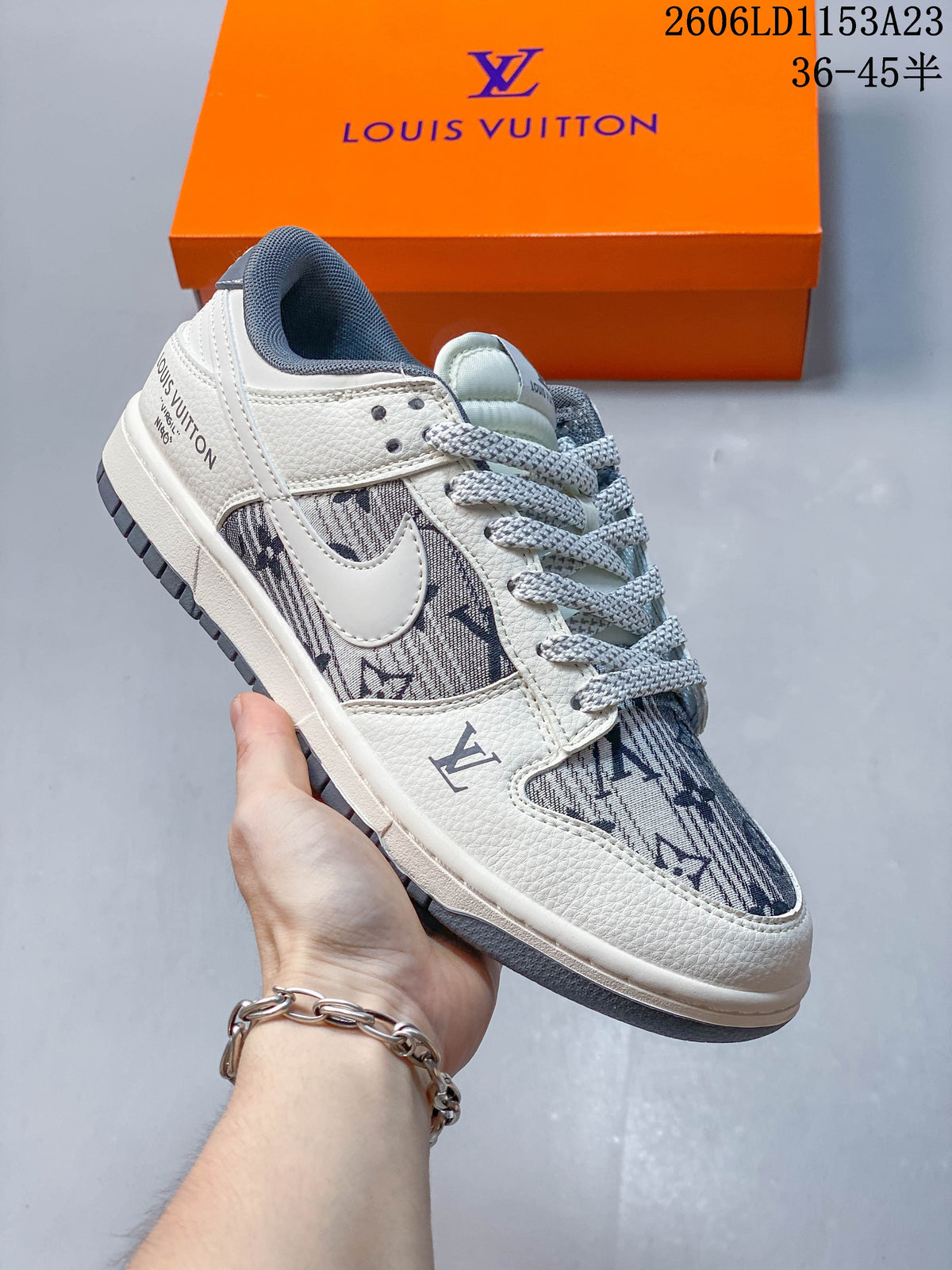 Close view of a white and gray patterned low-top sneaker with dark blue monogram-style print