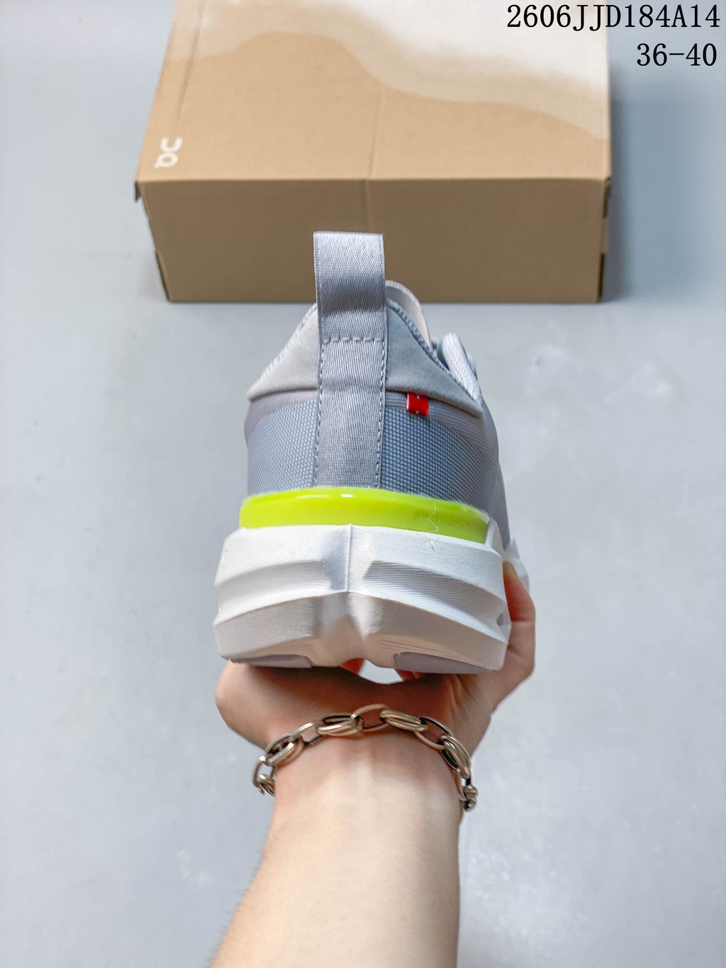 Rear view of a grey On Cloudpulse Next shoe showing the heel pull tab and yellow accent.