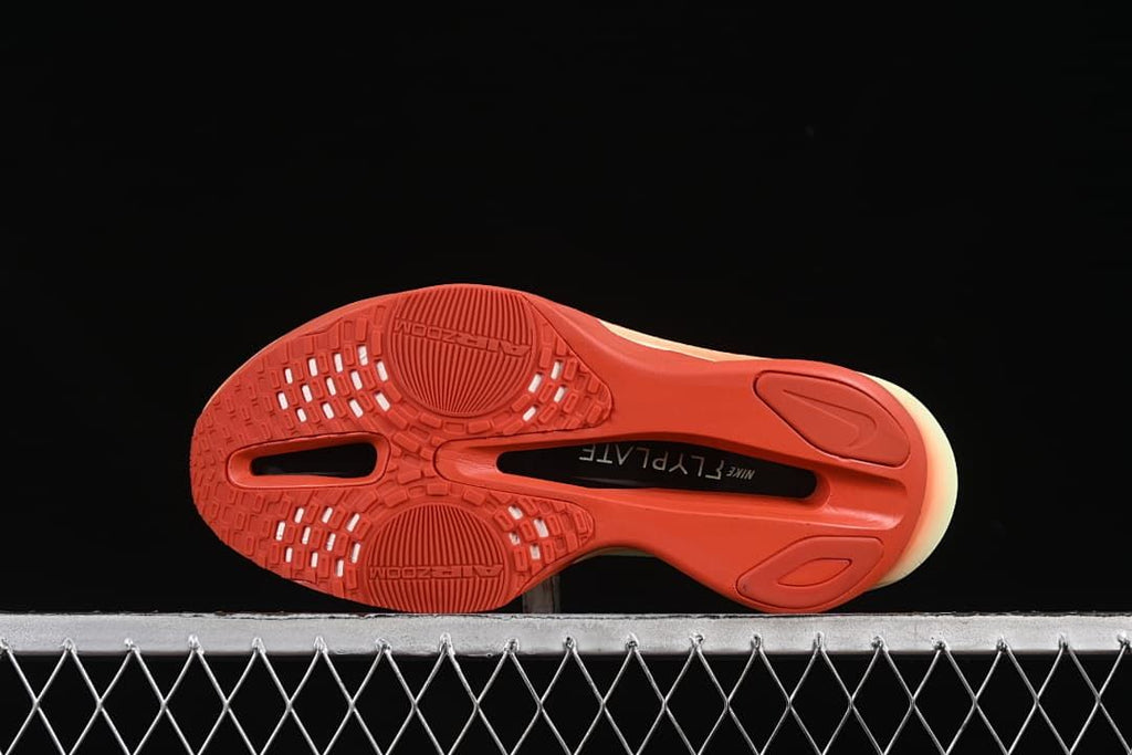 Underside view of the coral outsole with traction pattern and central cutouts