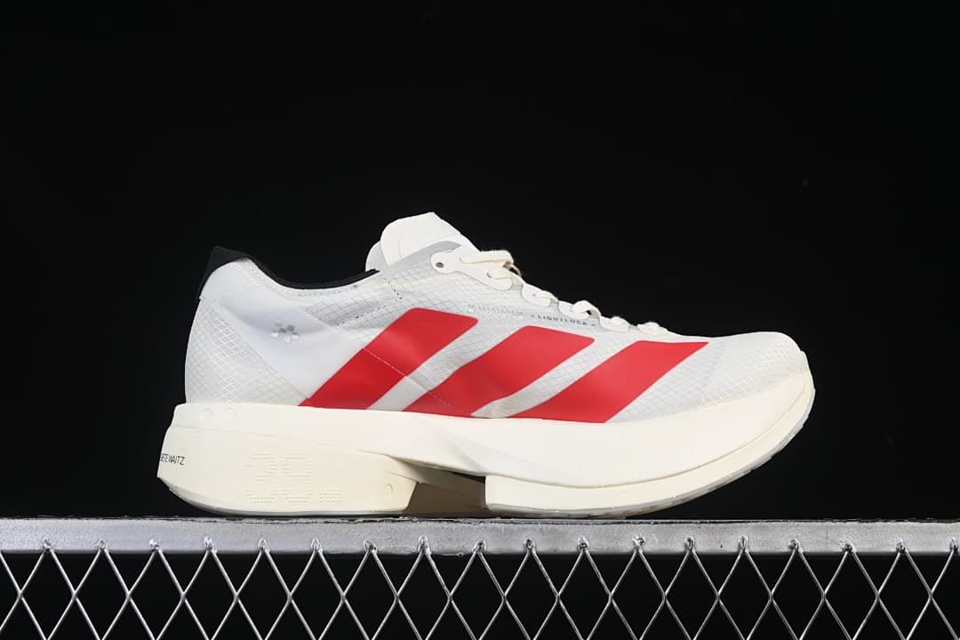 Side profile of the white running shoe with red stripes