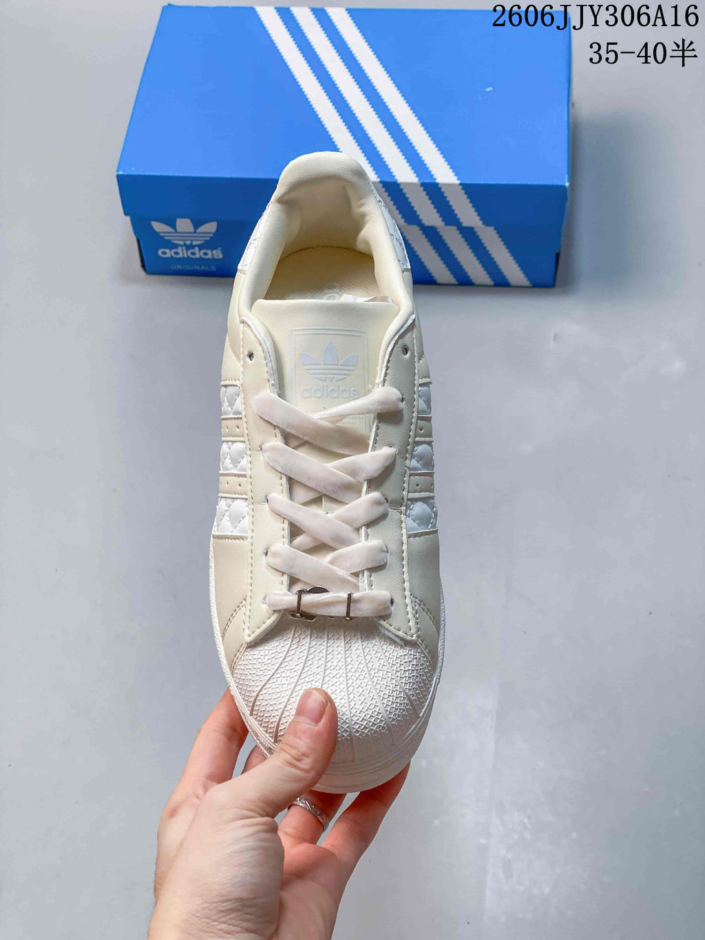 Top view of the lace-up sneaker with shell toe and decorative lace accessories