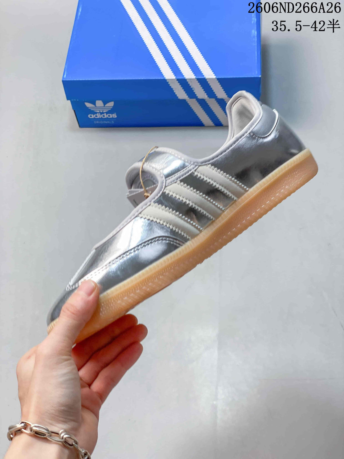 Side profile of the silver Samba Jane sneaker with light side stripes and a gum-colored outsole.