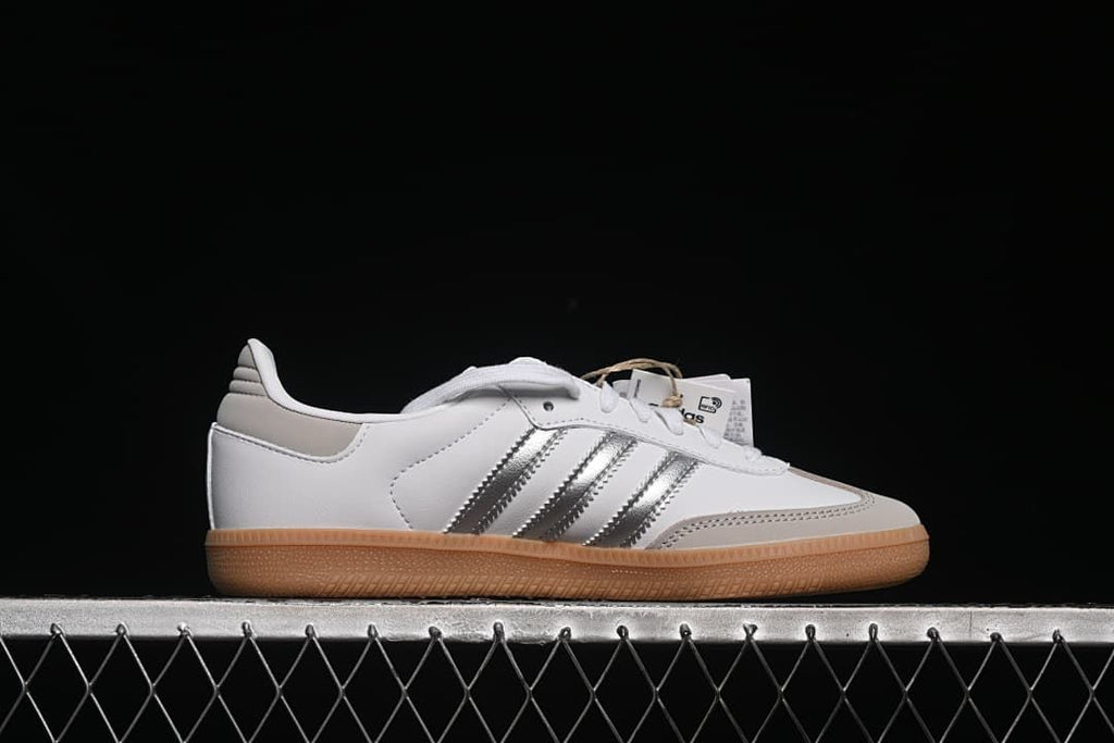 Side profile of a white sneaker with silver stripes and a gum outsole