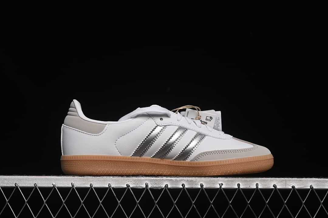 Side profile of a white sneaker with silver stripes and a gum outsole