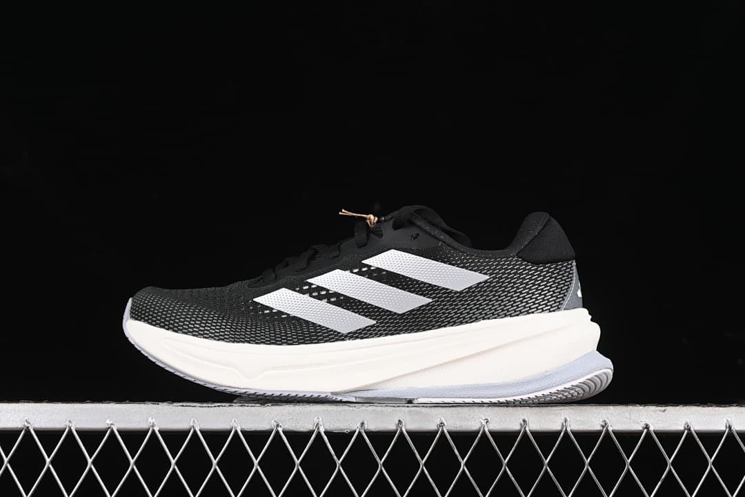 Side view of a black adidas Supernova Rise W running shoe with white stripes and a light-colored midsole.