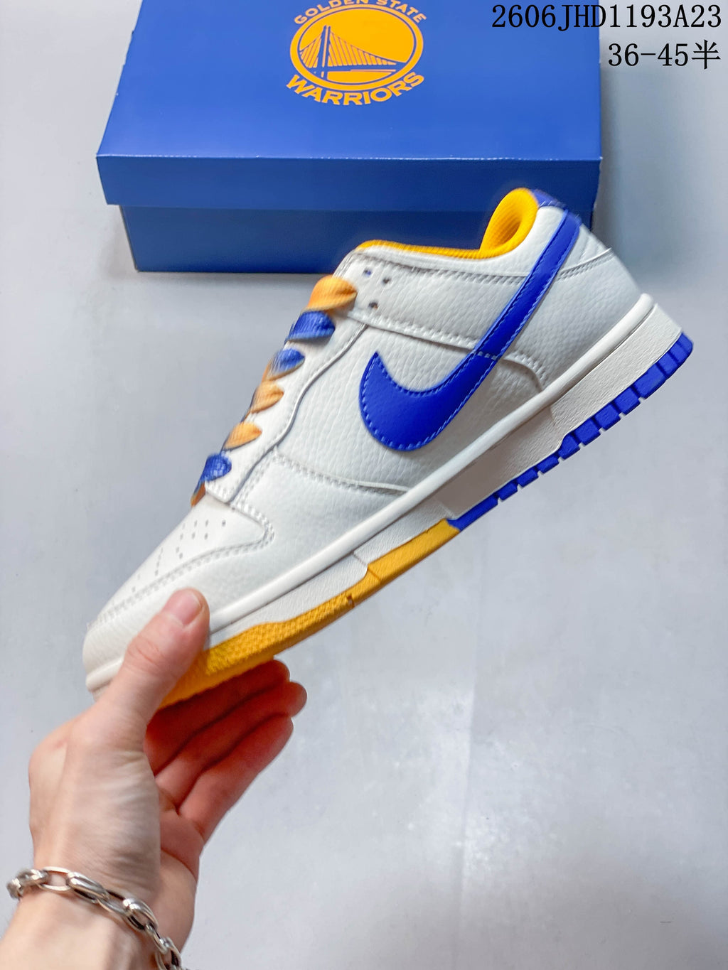 Side view of the white low-top sneaker with blue Swoosh and yellow outsole accents