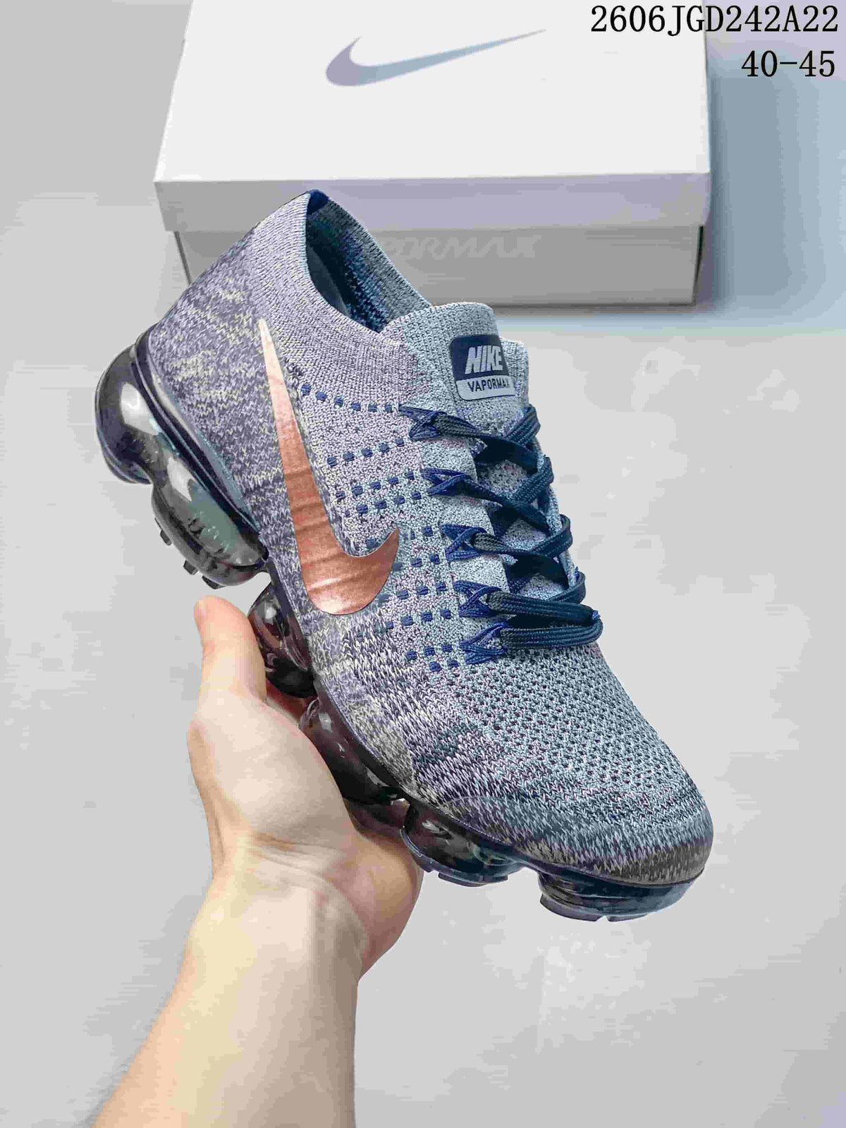 Angled view of a gray Nike VaporMax Flyknit sneaker with a copper-tone Swoosh and translucent sole