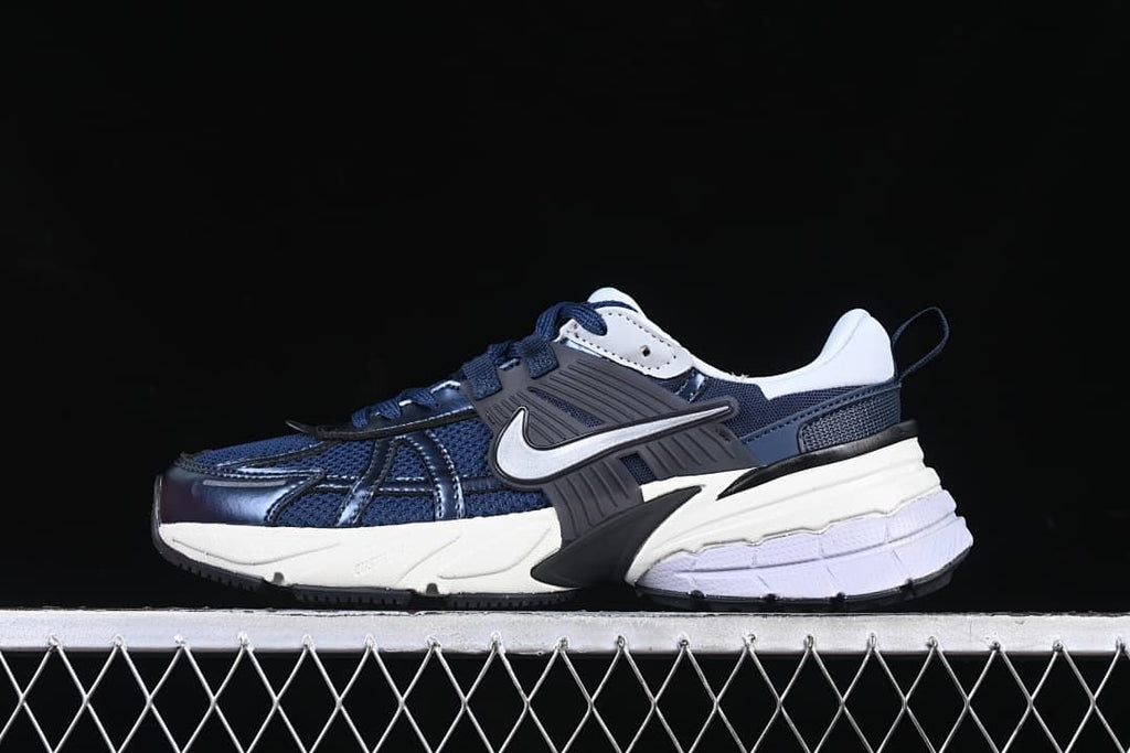 Side view of navy and white Nike V2K Run sneakers