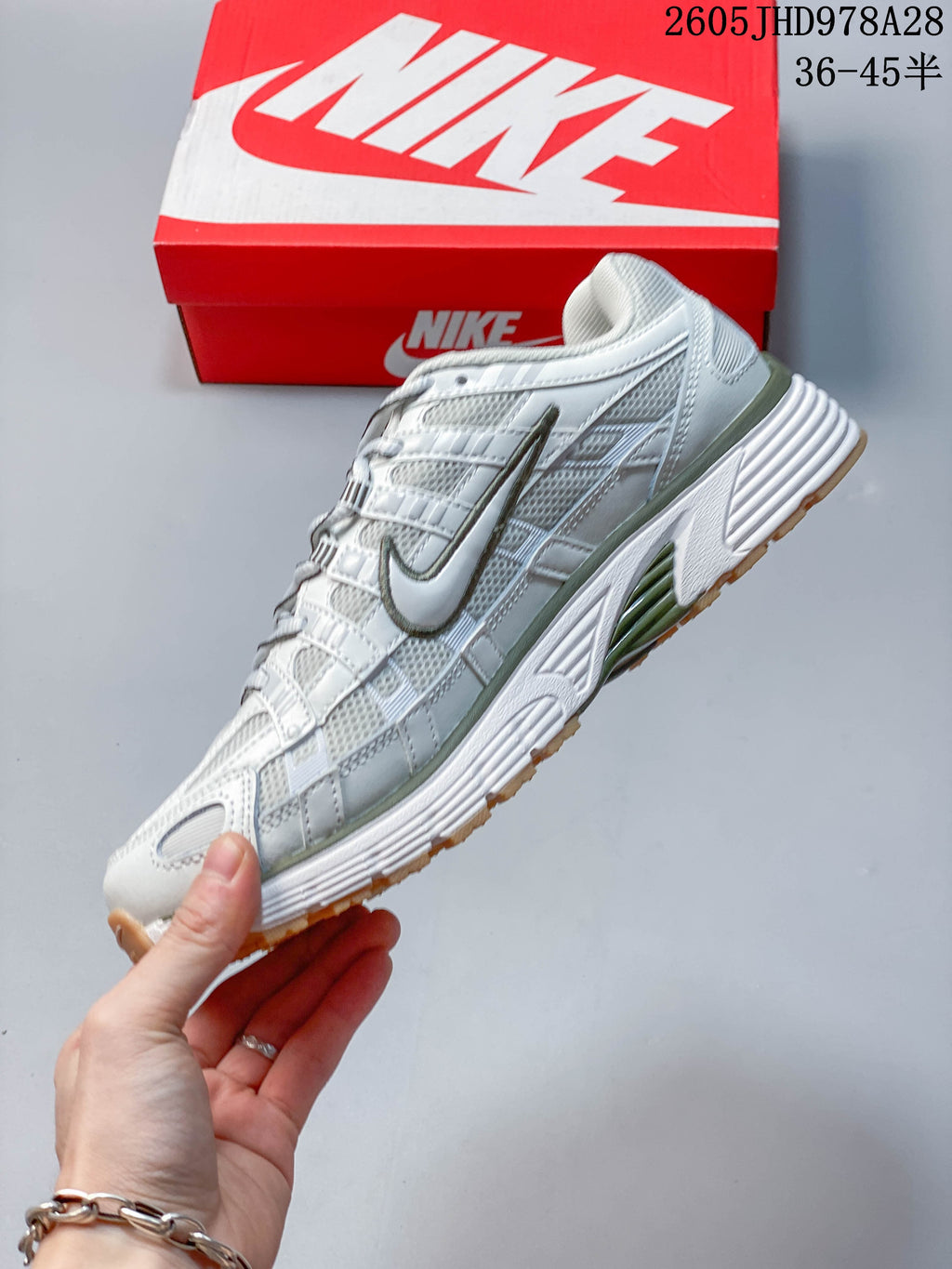 Side profile of a white Nike Initiator shoe with olive accents