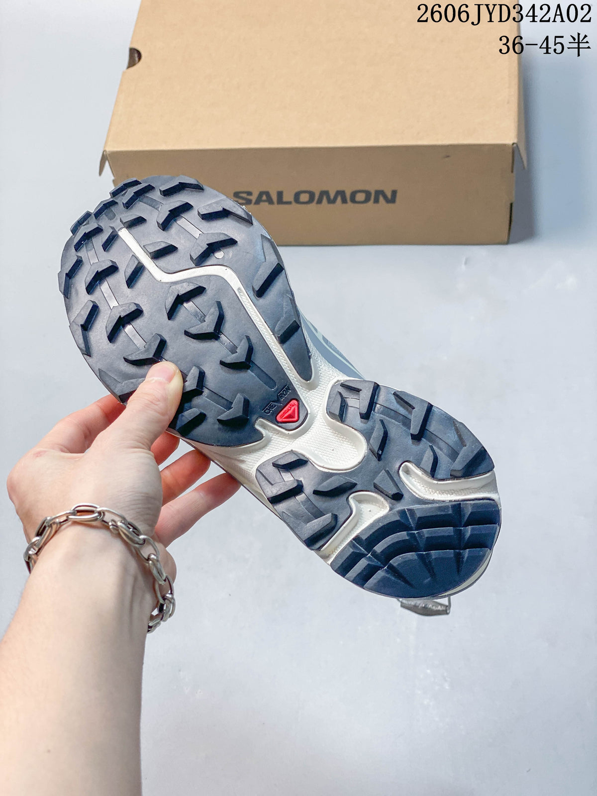 Close-up of the lugged outsole on a gray Salomon trail running shoe