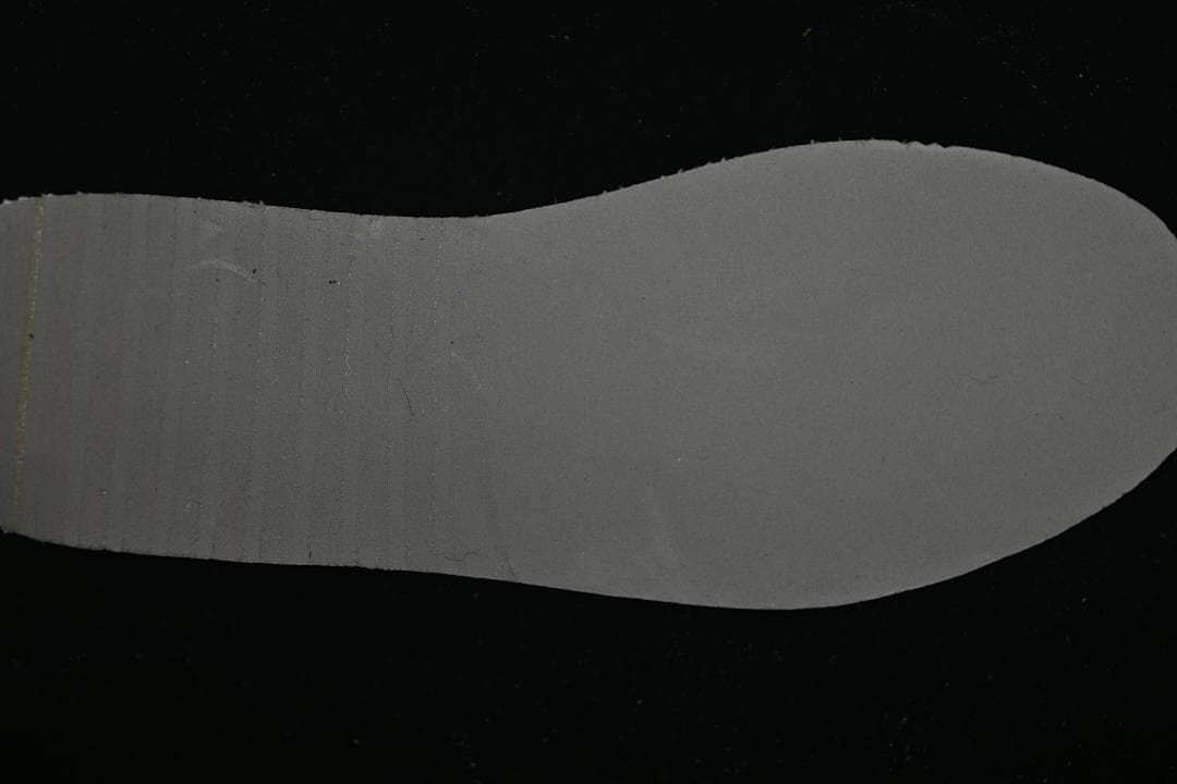 Plain dark insole shown against a black background