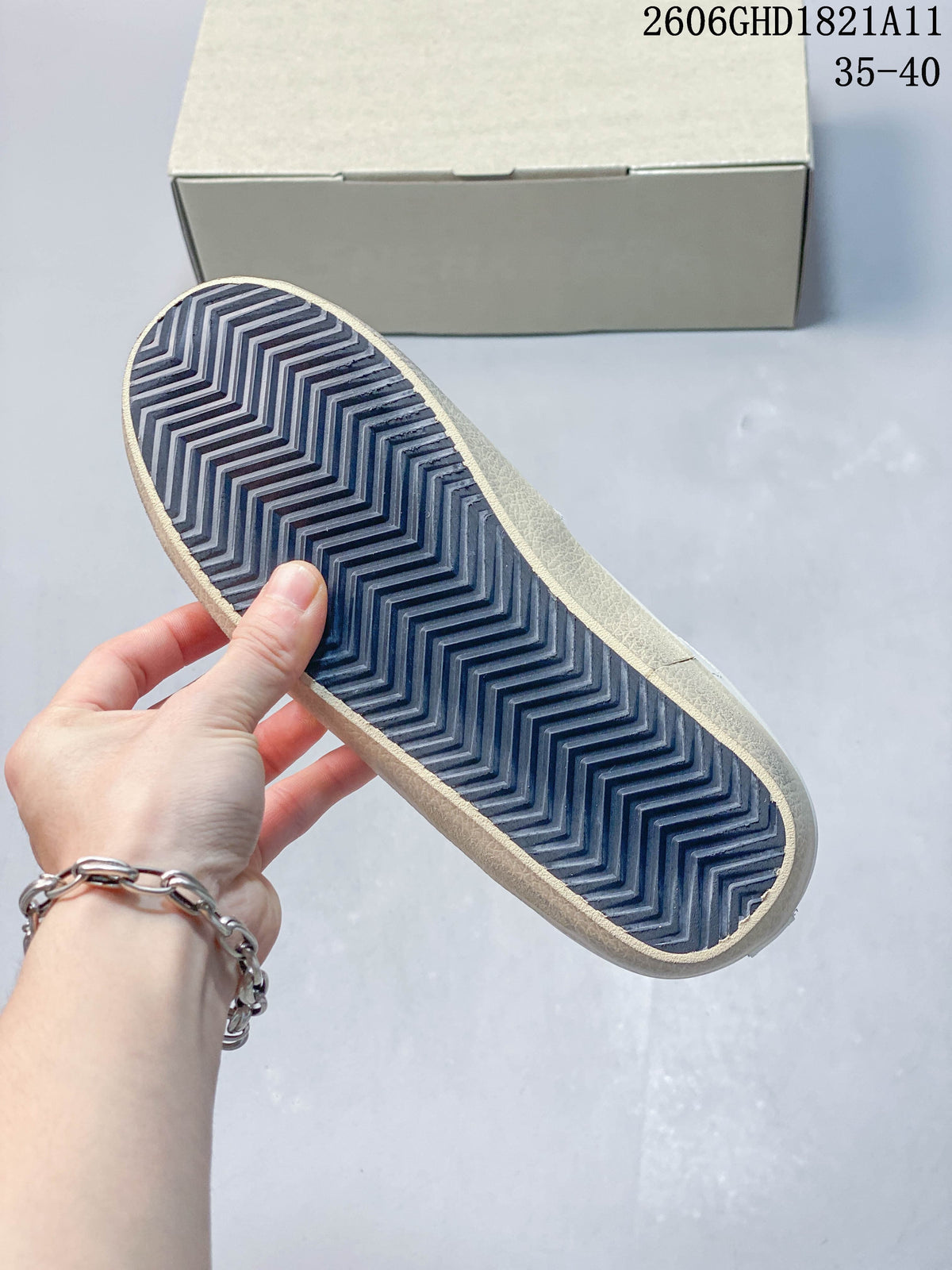 Underside of a sneaker showing a dark zigzag tread pattern