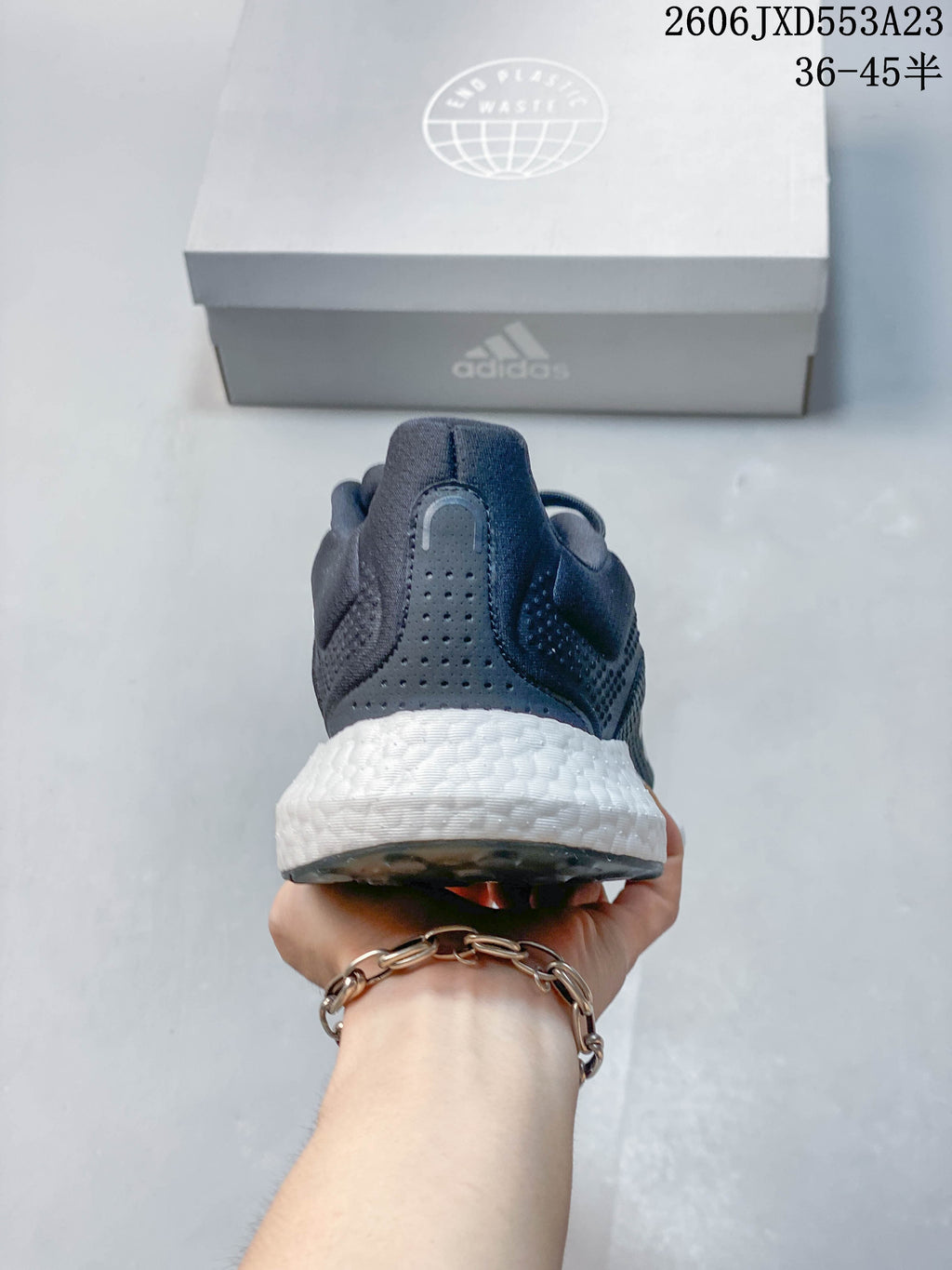 Rear view of a navy Adidas PureBoost 21 shoe showing the padded heel and white midsole.