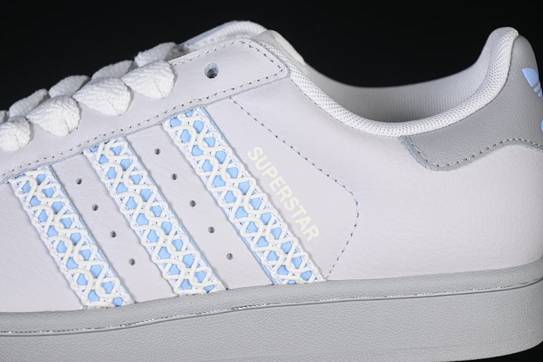 Close-up of the side stripes with pale blue patterned detailing and Superstar text.