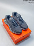Pair of dark gray Nike Journey Run running shoes displayed on an orange shoebox.