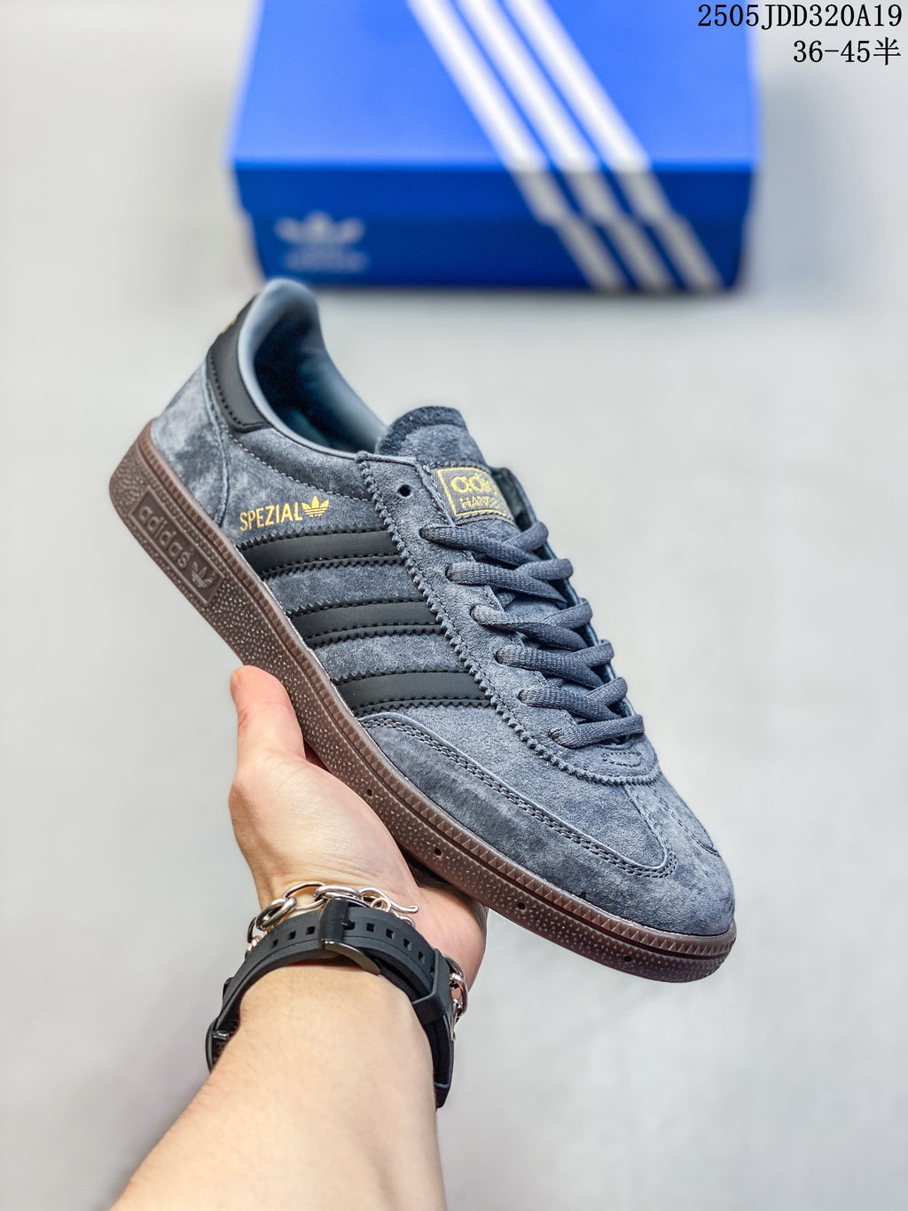 Angled side view of the grey sneaker with black stripes, gold side lettering and a brown gum-look sole.
