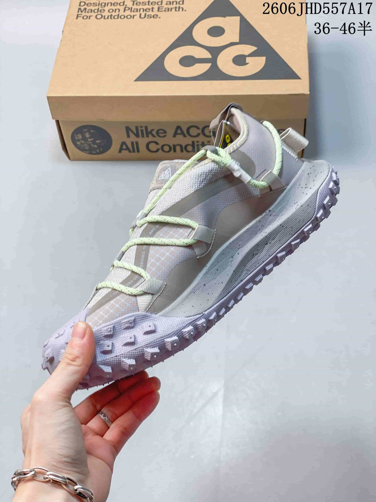 Side view of the sneaker showing its layered upper, mint-green laces, and rugged outsole.