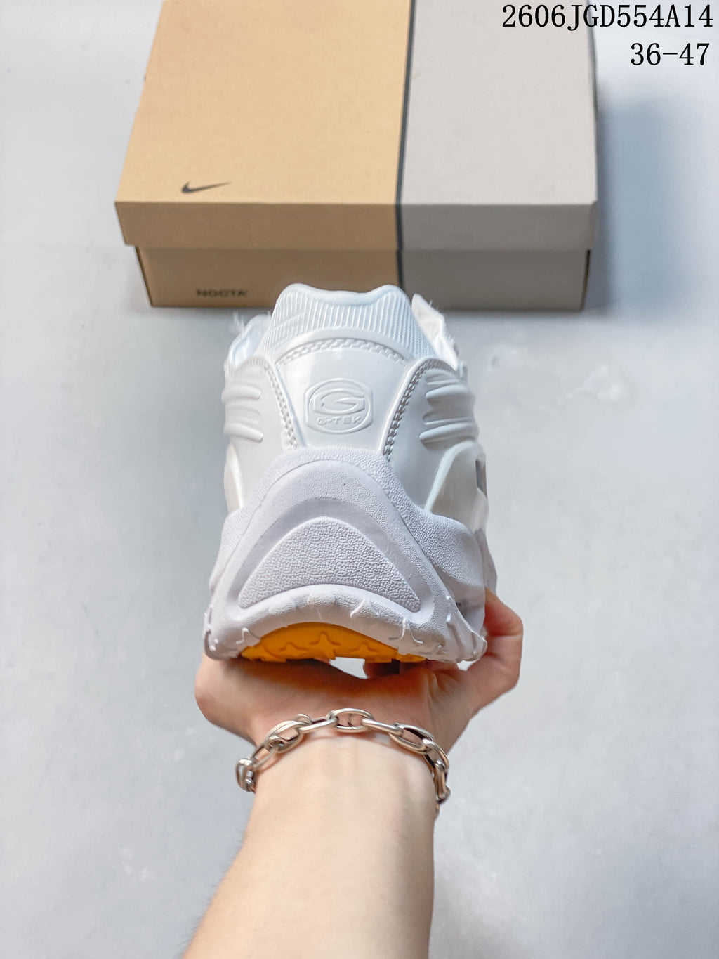 Rear view of the white sneaker with sculpted heel detailing