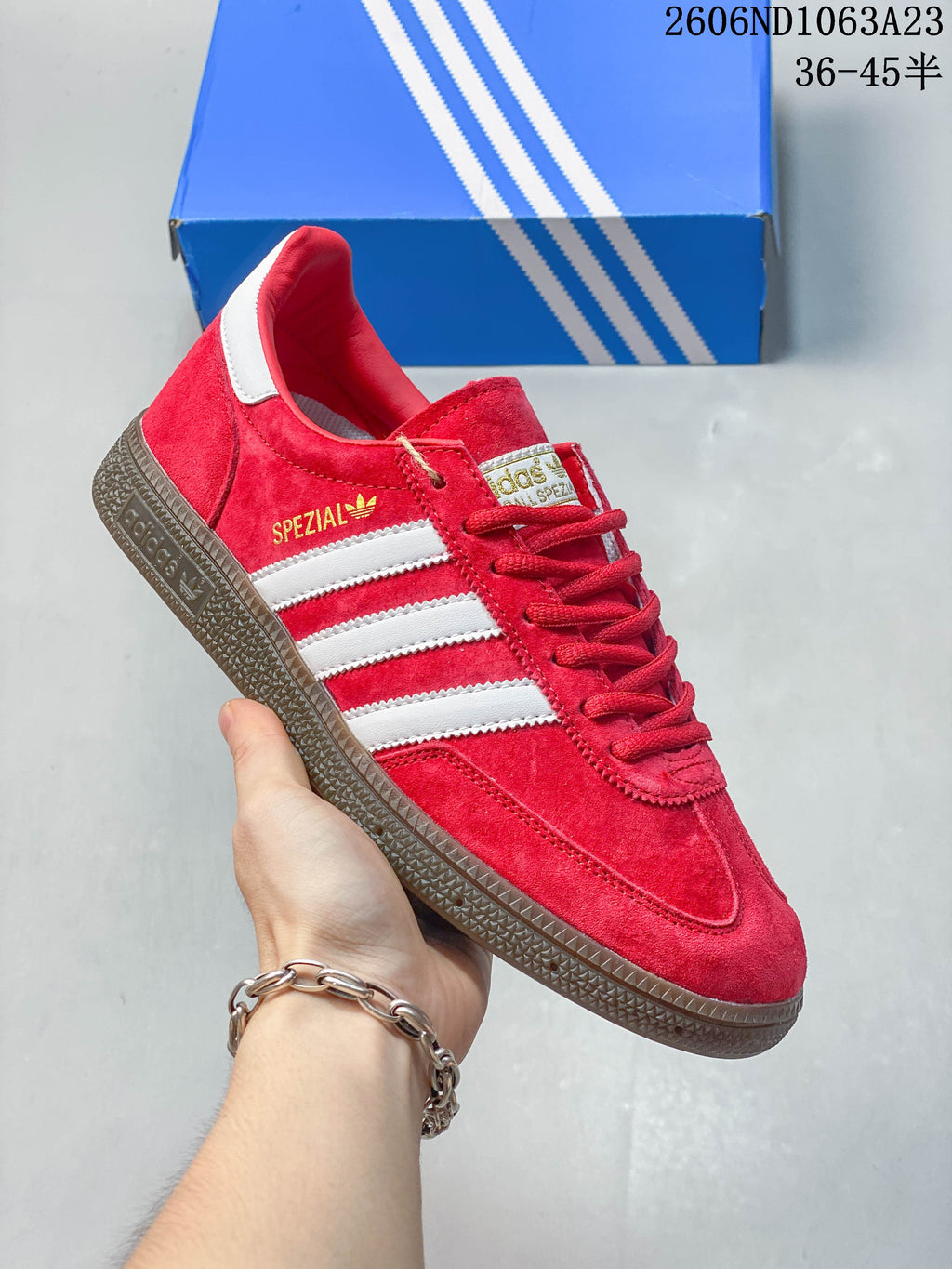 Red Adidas Spezial low-top sneaker with white stripes and a dark gum-toned sole.