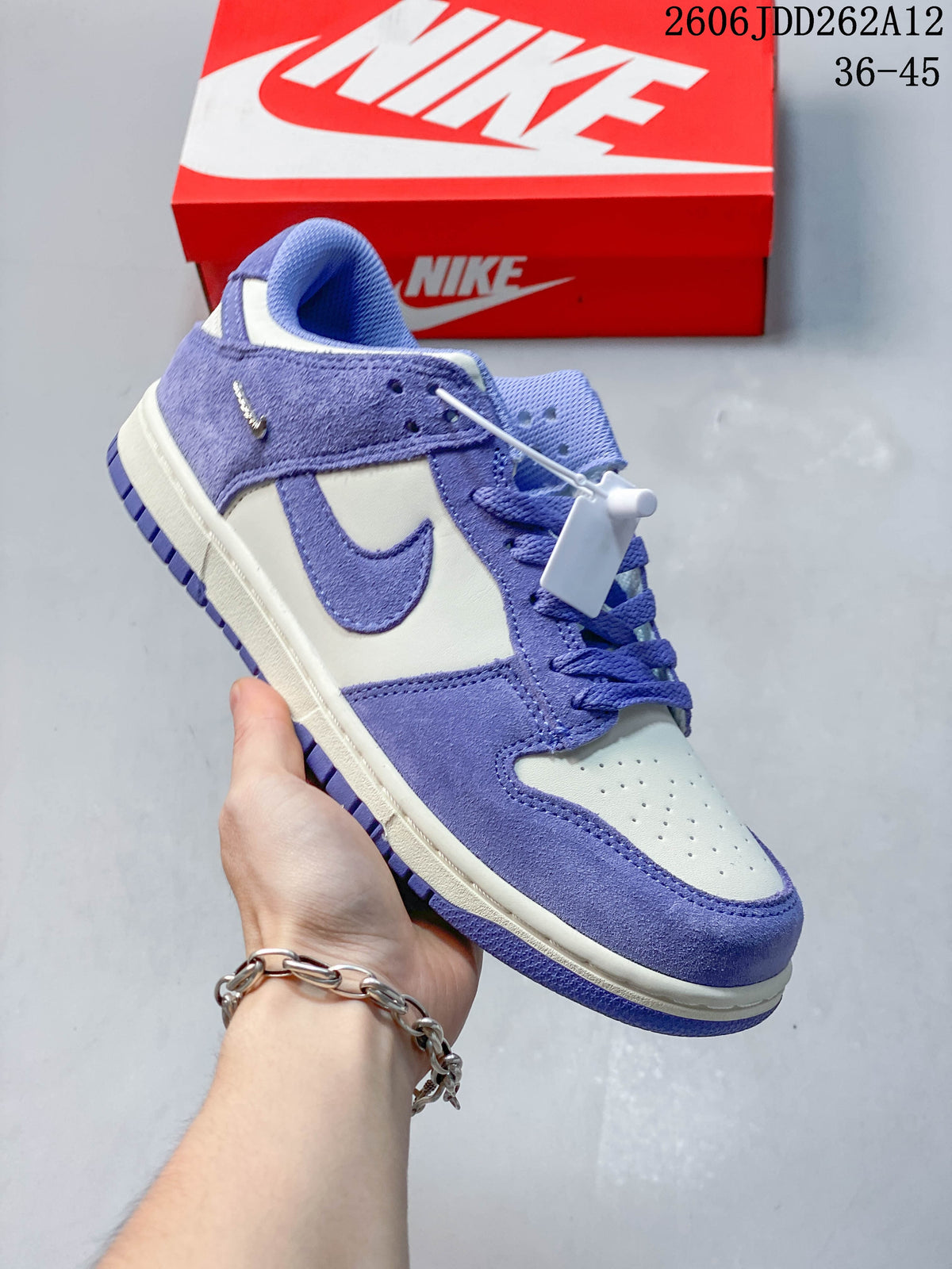 Side view of a purple and Sail Nike low-top sneaker with a perforated toe and lace-up fastening.