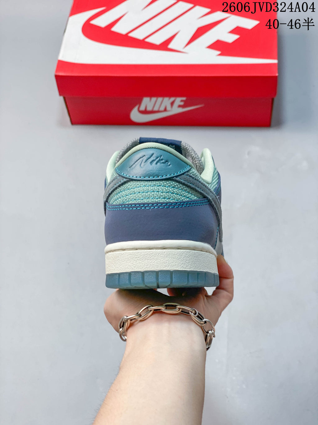 Rear view of a gray and blue Nike Dunk Retro SE low-top sneaker