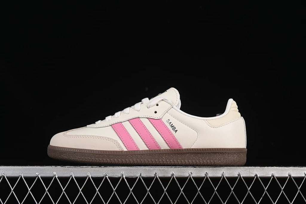 Side view of an off-white adidas Samba OG sneaker with pink stripes and a gum outsole