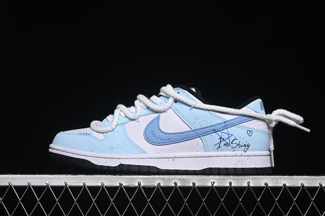 Side view of a white and light-blue low-top sneaker with graphic details and oversized rope laces