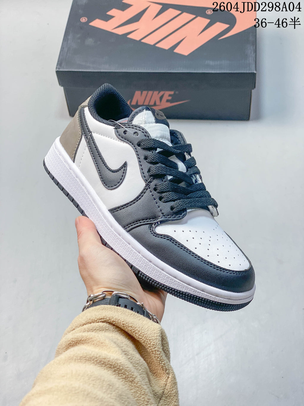 Angled side view of the white, dark brown and grey low-top sneaker