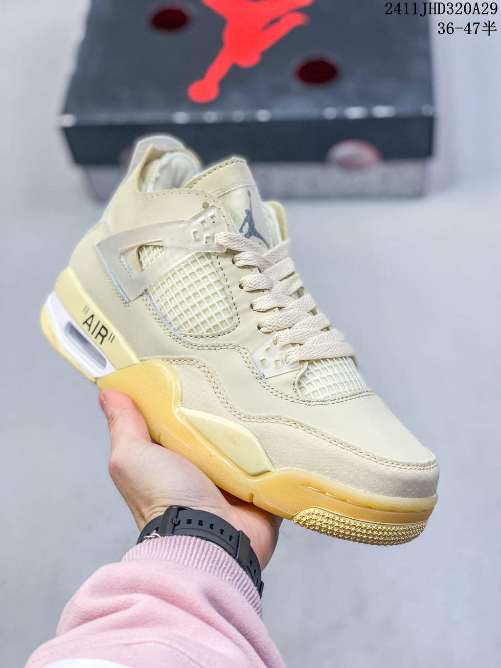 Angled side view of the light-colored sneaker with pale yellow outsole accents.
