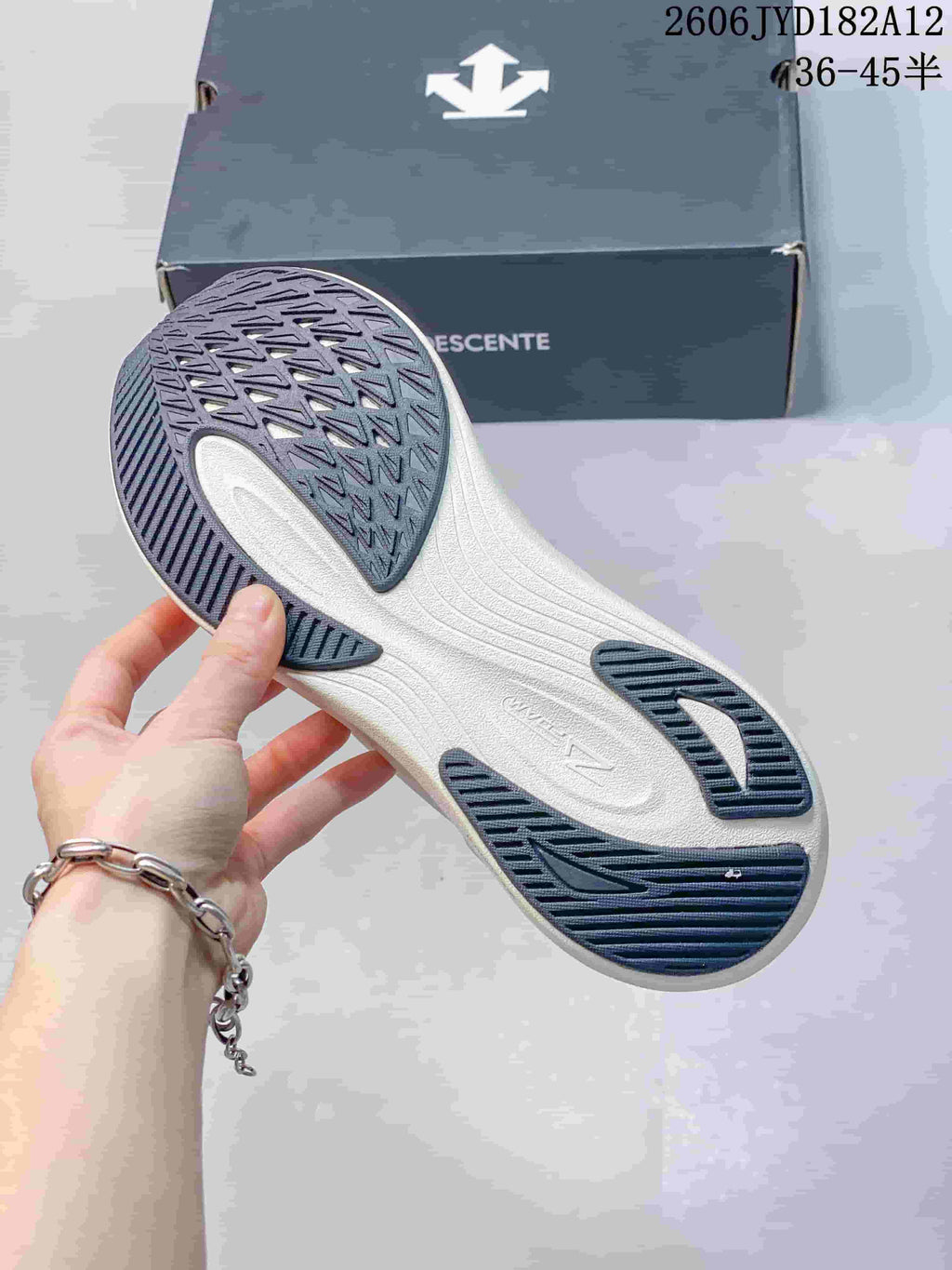 Underside of the sneaker showing a patterned dark outsole and light midsole.