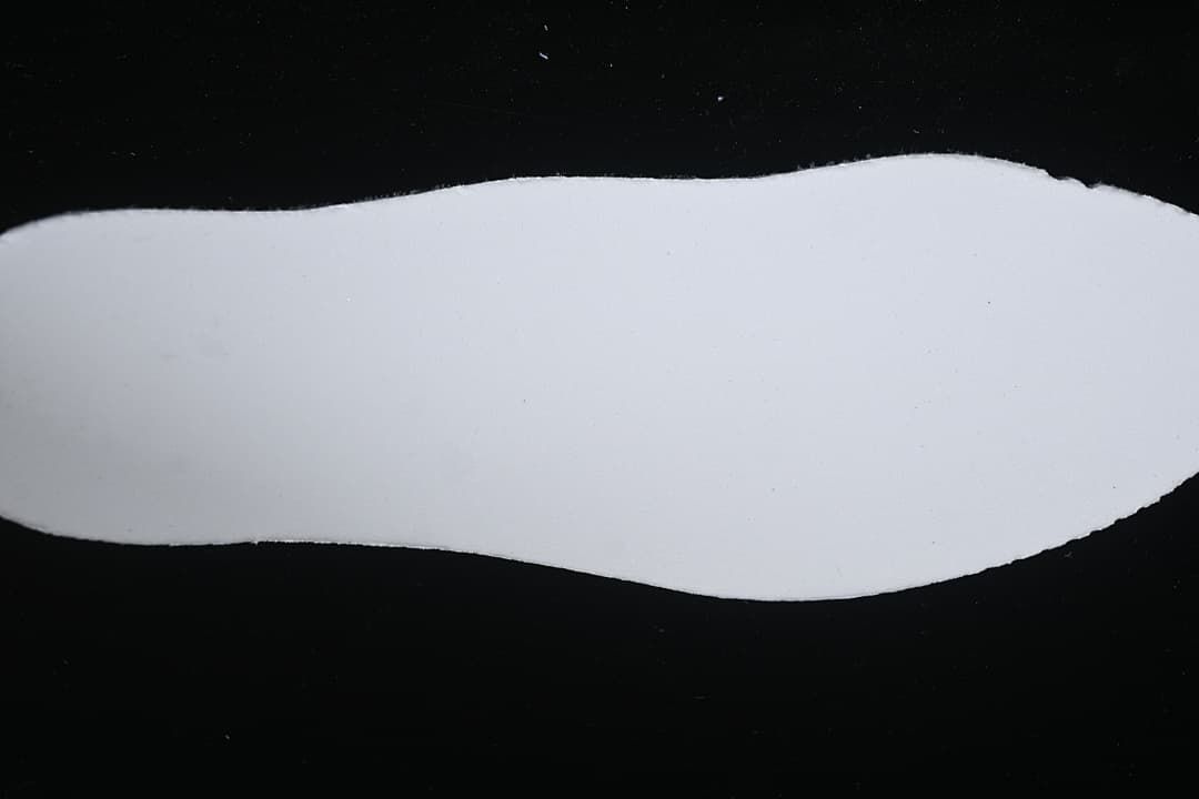 Plain white shoe insert shown against a black background