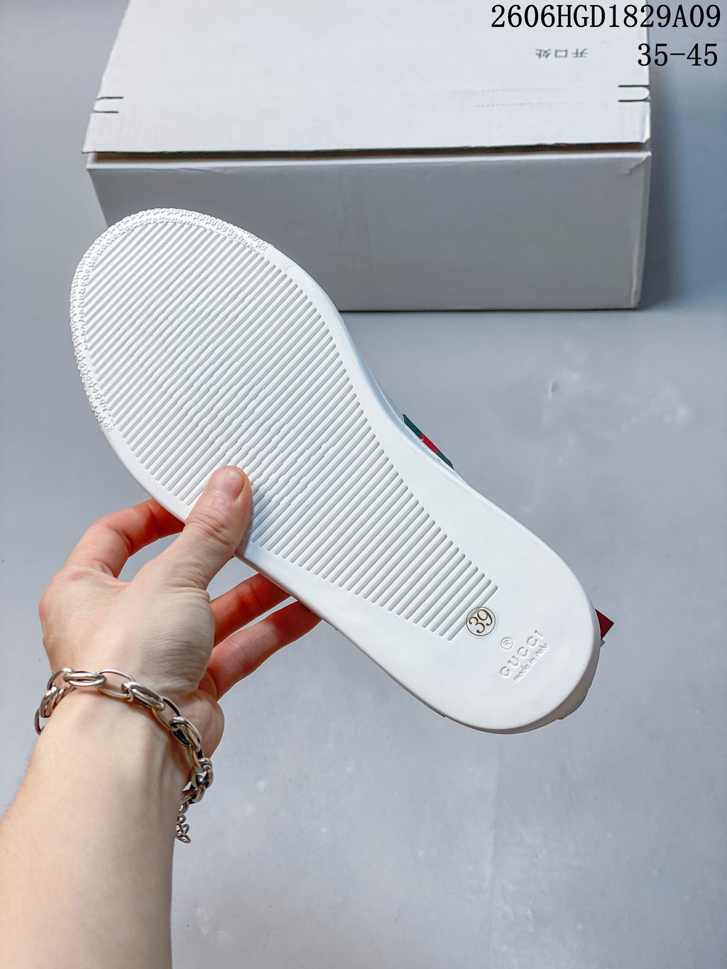Underside of a white sneaker showing a ridged sole and a size 39 marking.