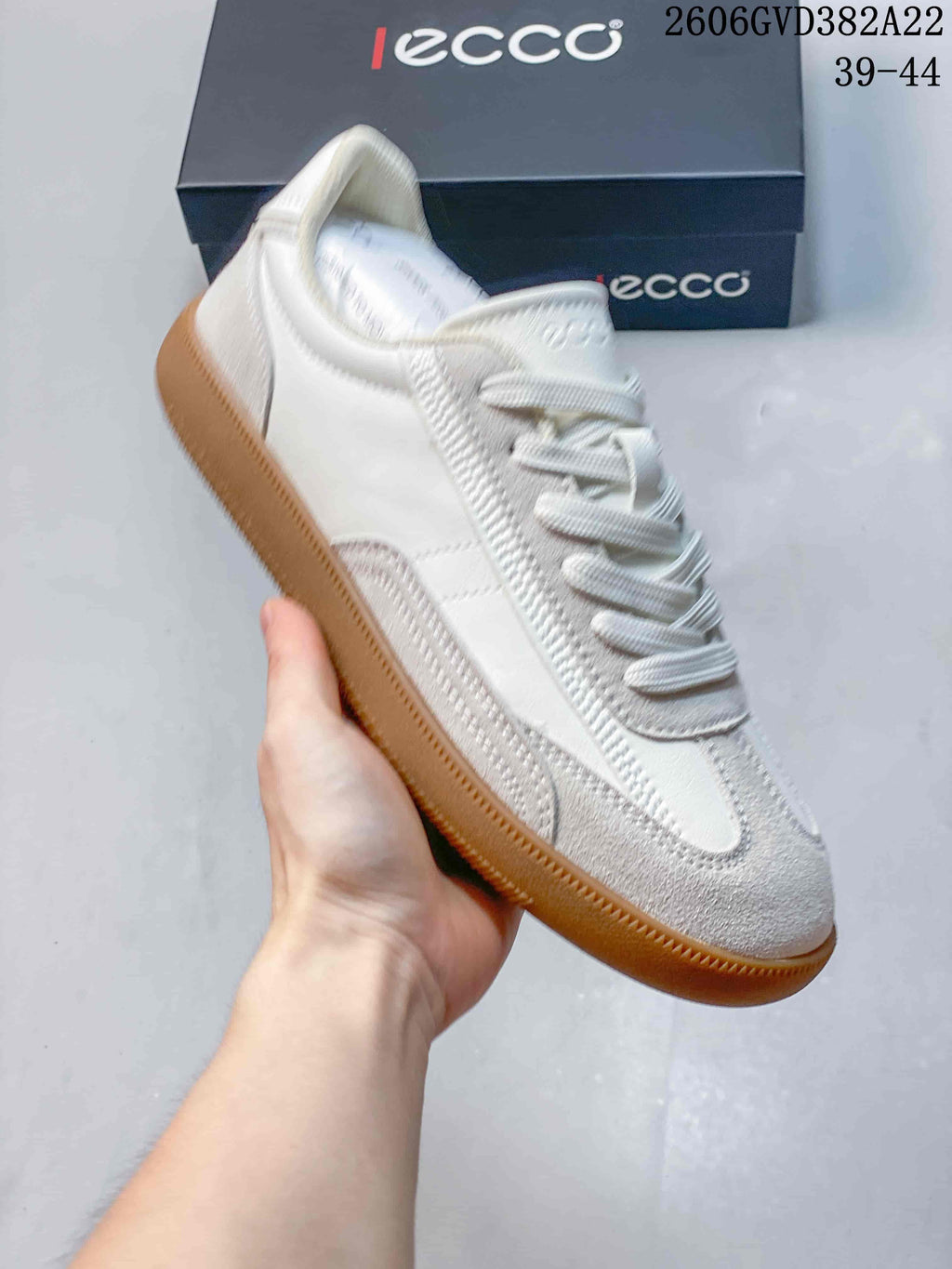 Angled view of a light-colored casual sneaker with a gum-colored sole