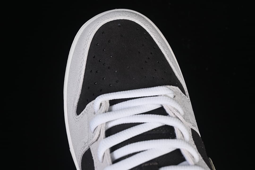 Top-down close-up of the perforated black toe and white laces.