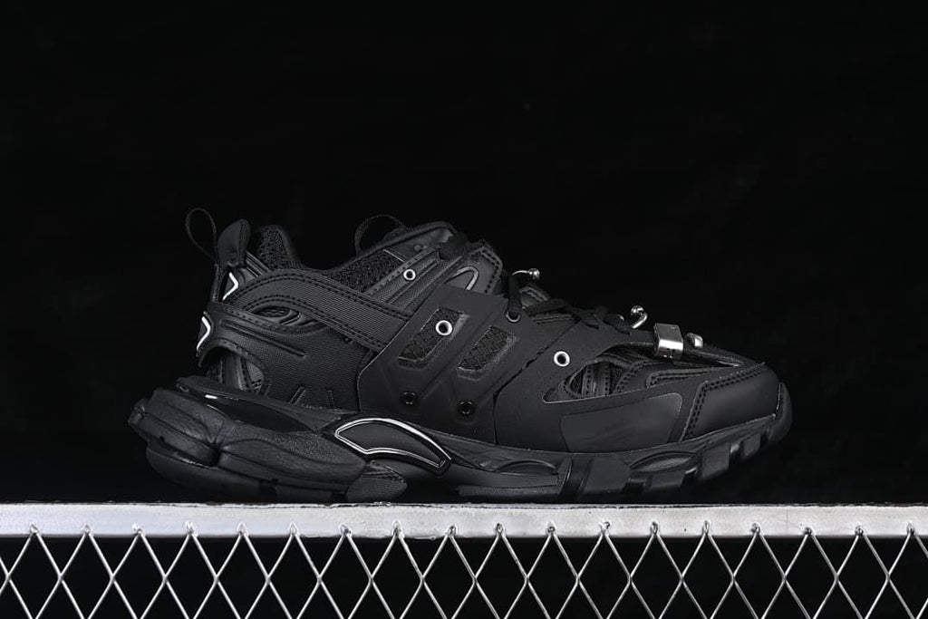Side profile of the black sneaker with layered panels and chunky sole