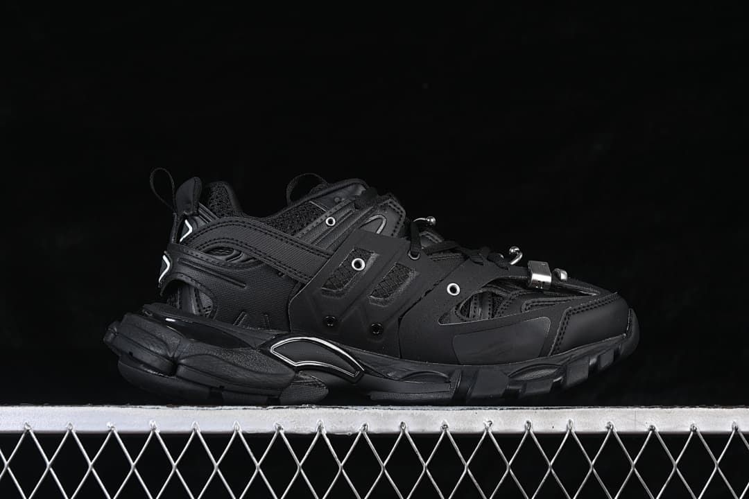 Side profile of the black sneaker with layered panels and chunky sole